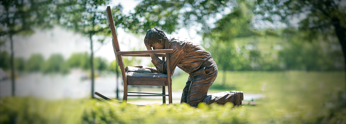 A statue of a man kneeling in prayer