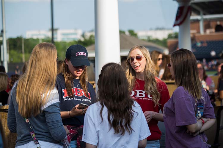 Dallas college students talking outside at baseball game