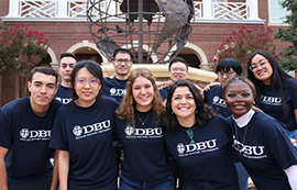 group of students standing outside by globe