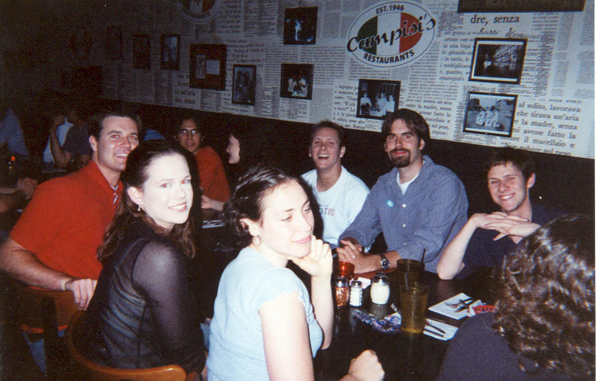 picture of a group of people sitting around a table smiling at a restaurant