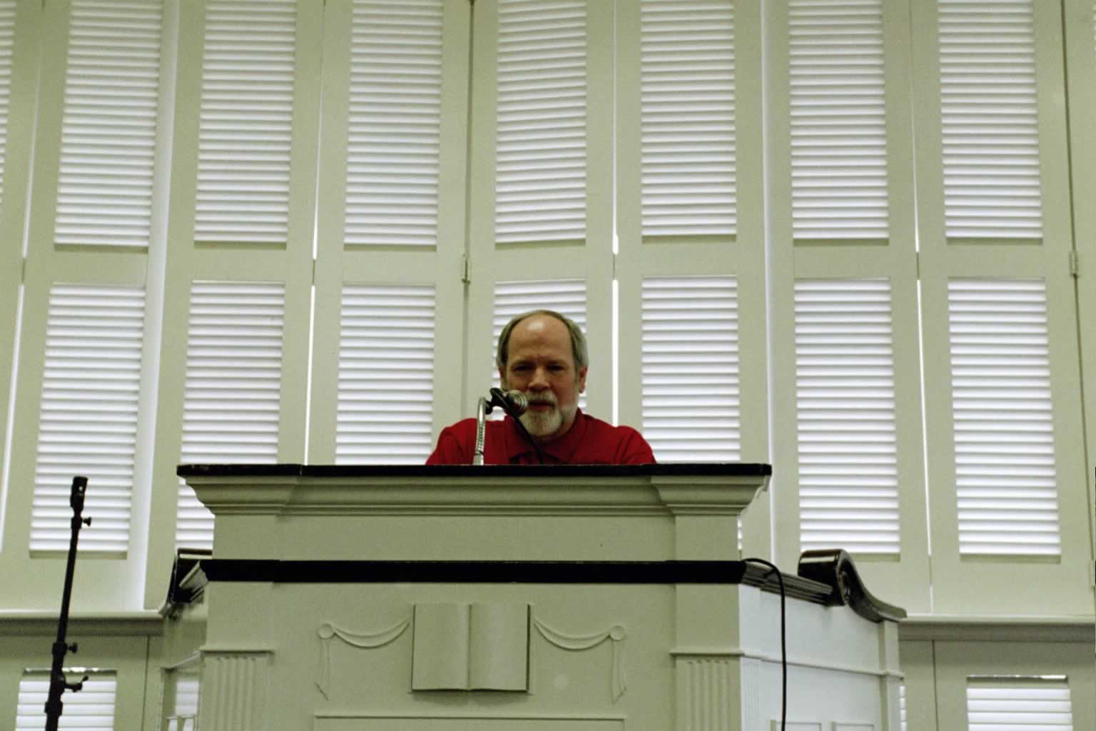 picture of Dr. Naugle standing behind a podium speaking