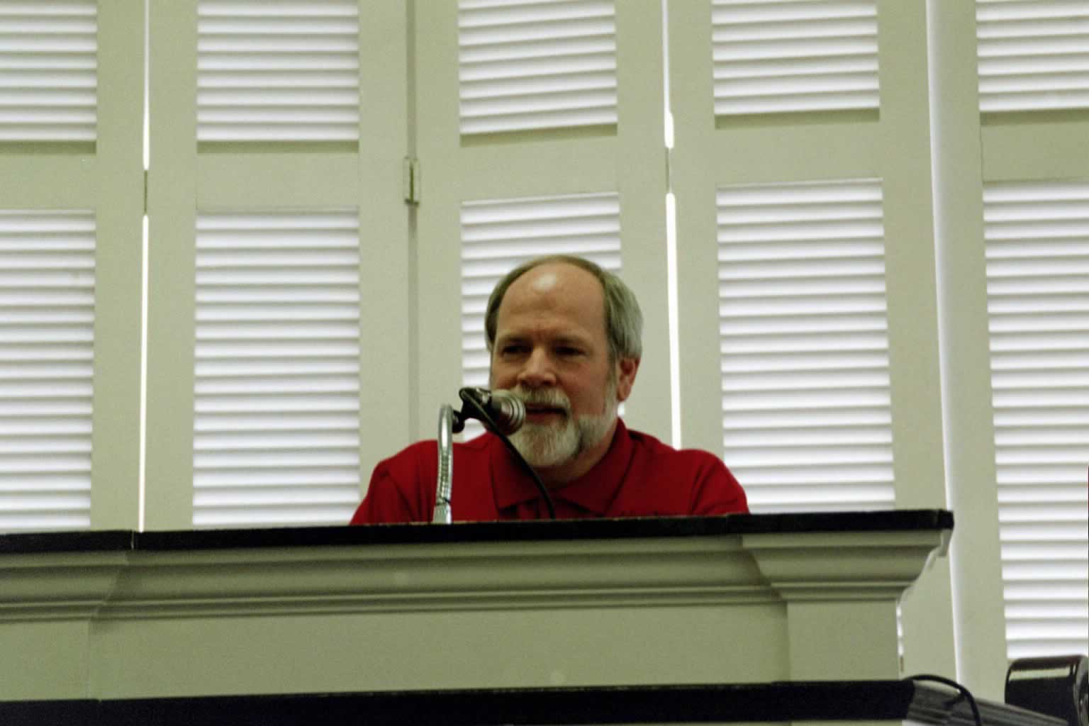 picture of Dr. Naugle standing behind a podium and speaking