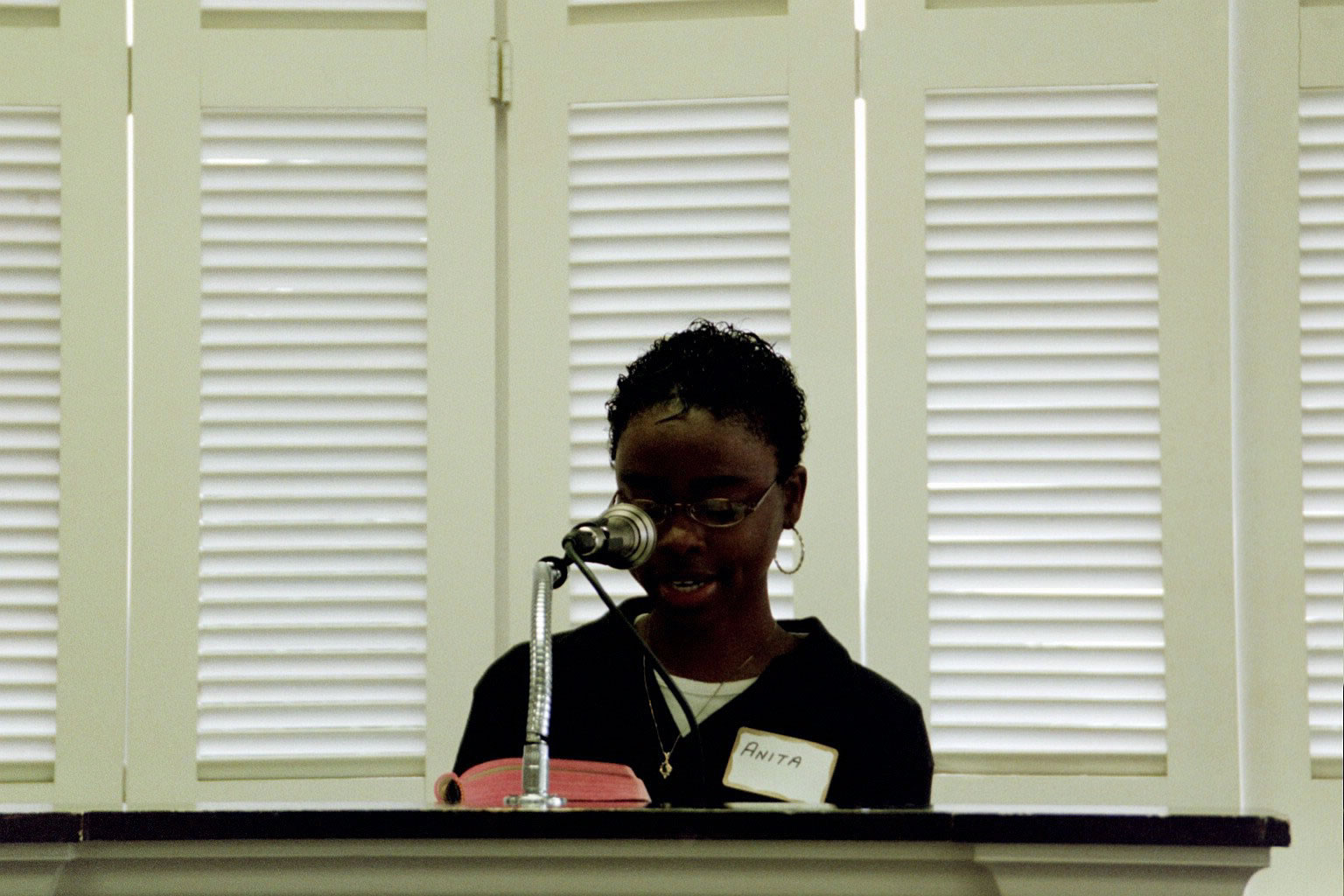 picture of a women reading behind a podium