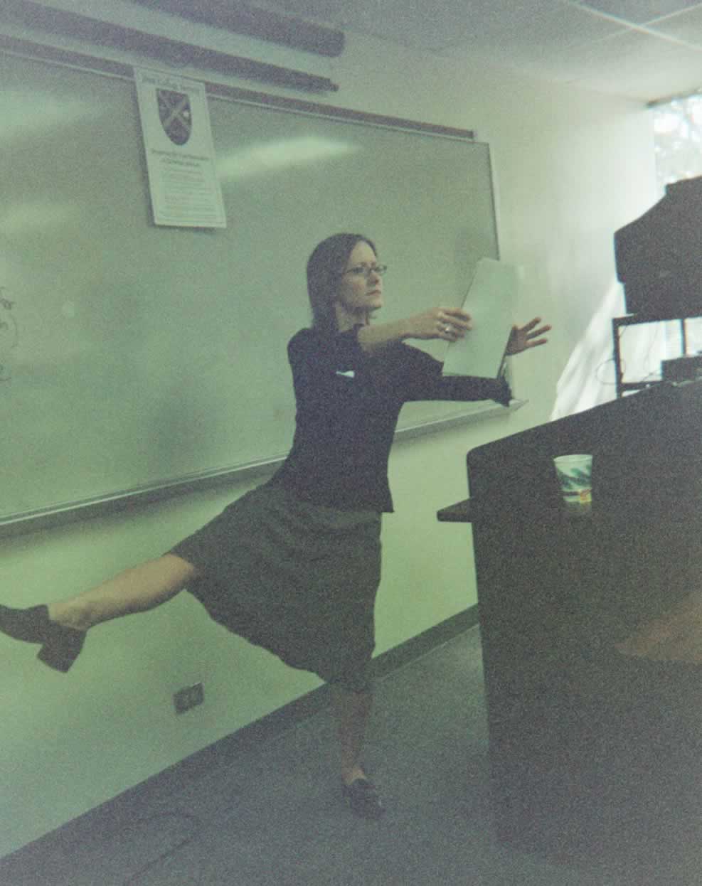 picture of a student presenting behind a podium while posing