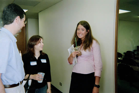 picture of a woman in a pink shirt smiling while holding a cup in her hand