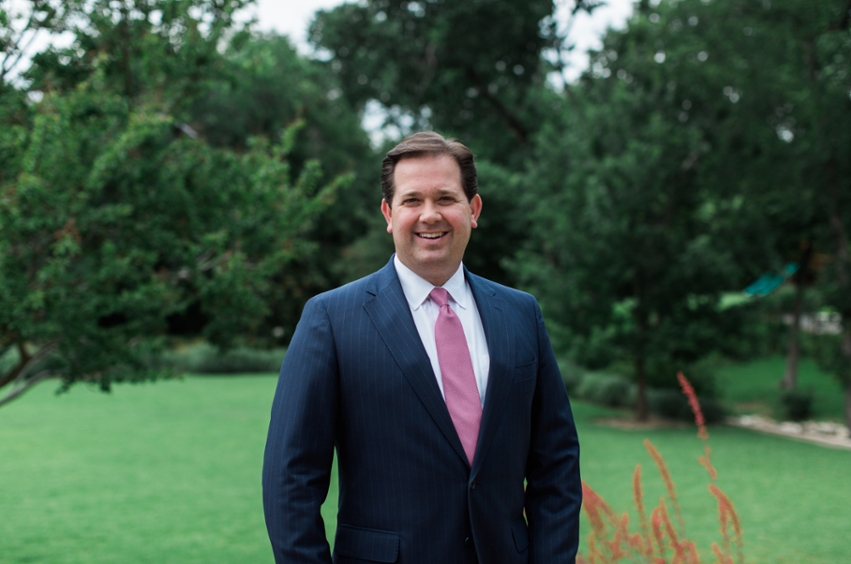 Dr. Wright is standing in front of trees, smiling. 