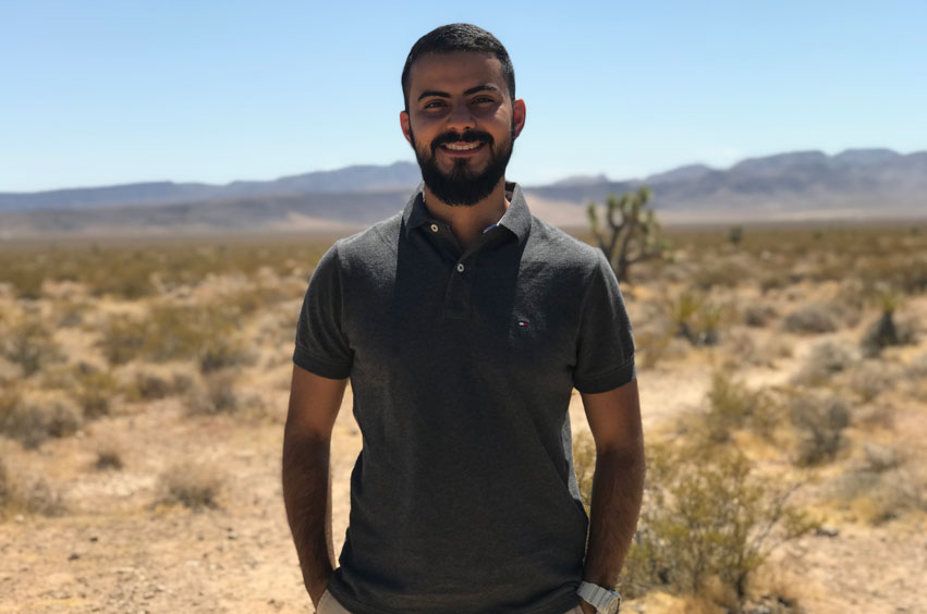 guy standing outside in desert looking background