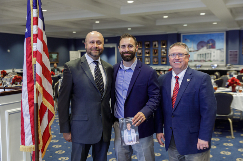 three men standing in Sadler Hall at the veterans day reception