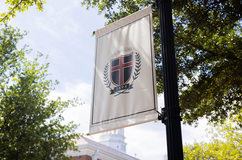 A banner with the DBU logo on the DBU campus in Dallas