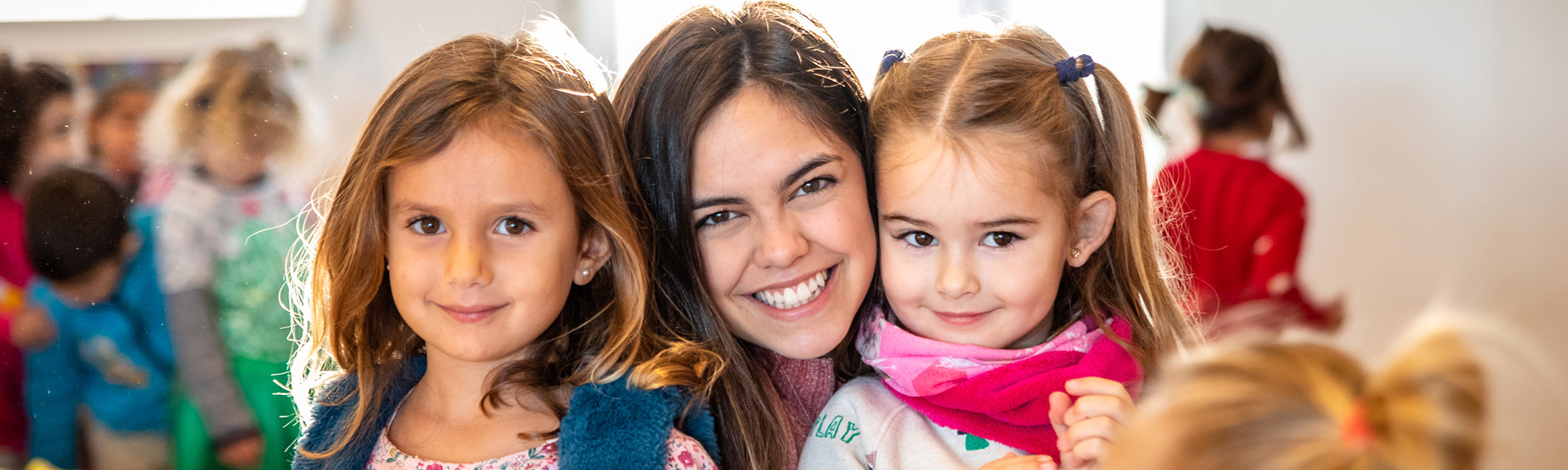 a student smiles with two children