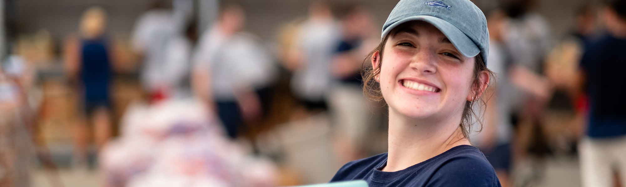 a girl carries a tub to help on move-in day