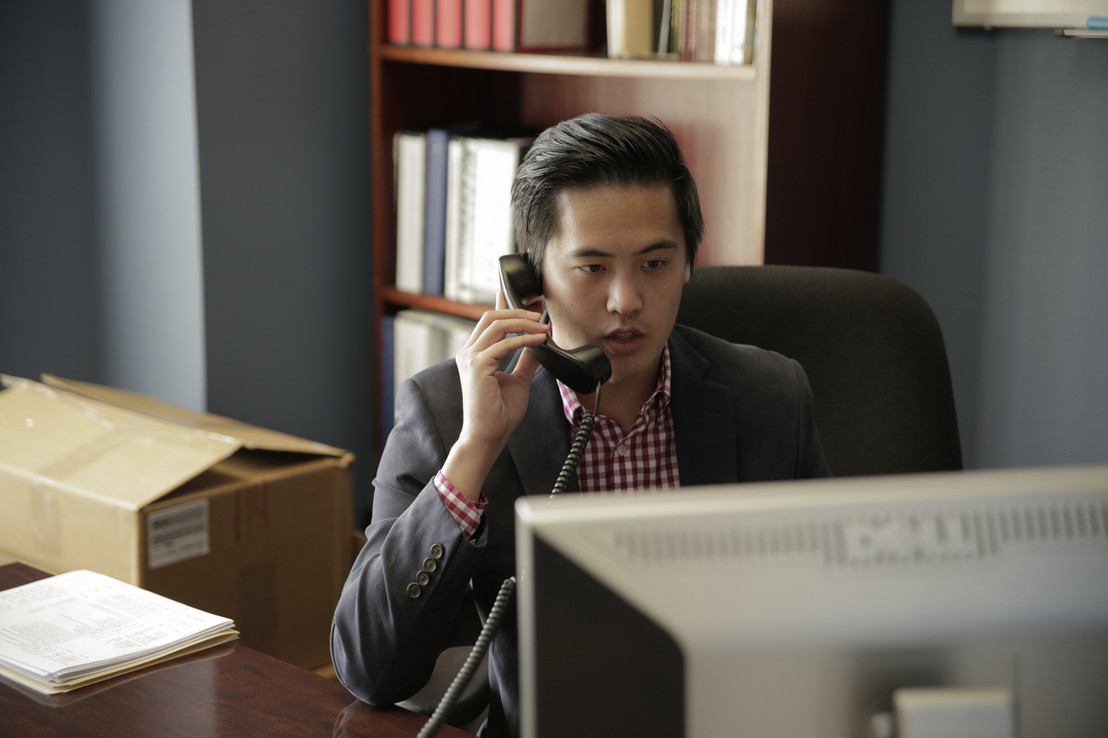 businessman sitting at his work desk talking to someone on the phone in Dallas, Texas