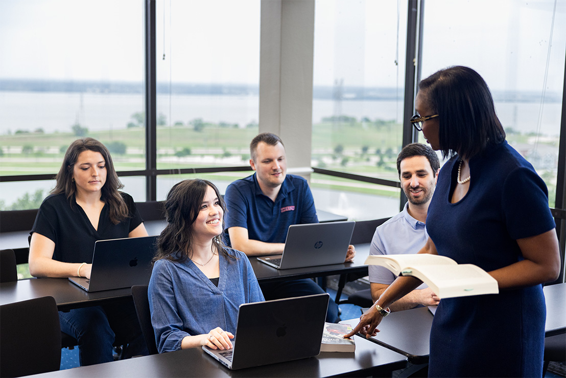 graduate students in Dallas, Texas sitting around a table learning in class 