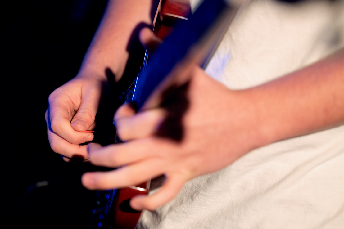 Closeup photo of Dallas college student playing the guitar