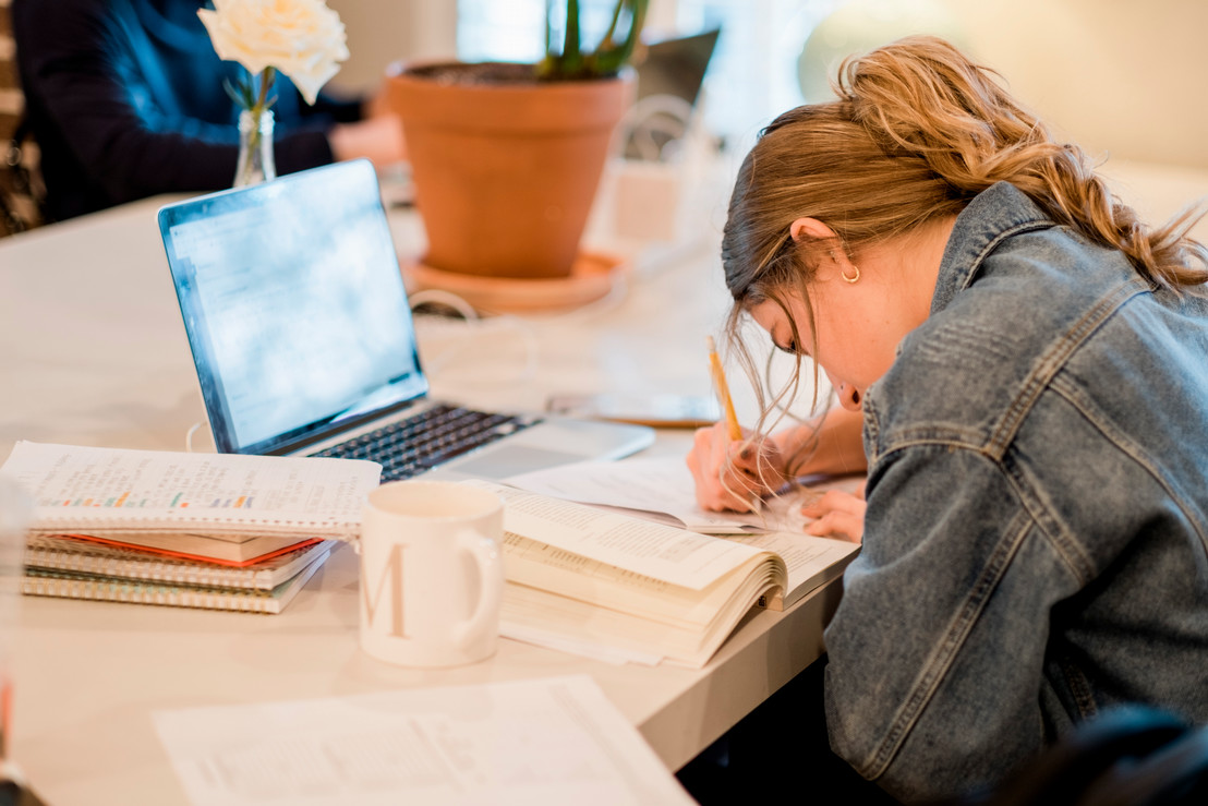 College female student working on her finances at a table at a local coffeeshop in Dallas, Texas