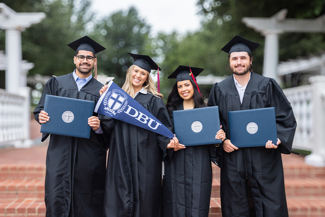 DBU graduates posing with their degrees