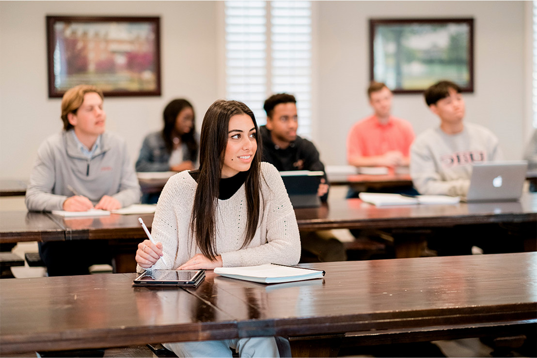 A girl focuses on the professor in a classroom setting
