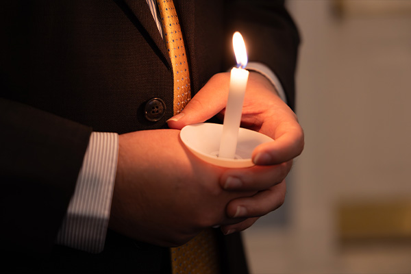 DBU graduate holding a candle