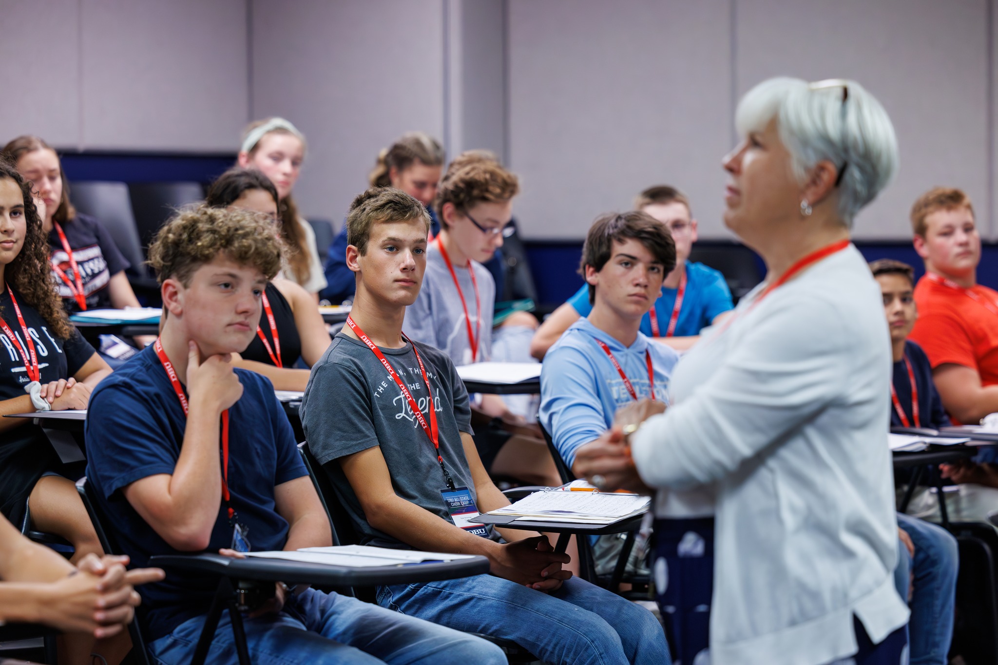 A classroom of students listening to a female instructor.