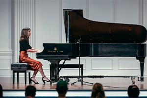 student playing piano on a stage