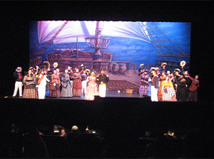 A stage filled with a large audience watching a performance