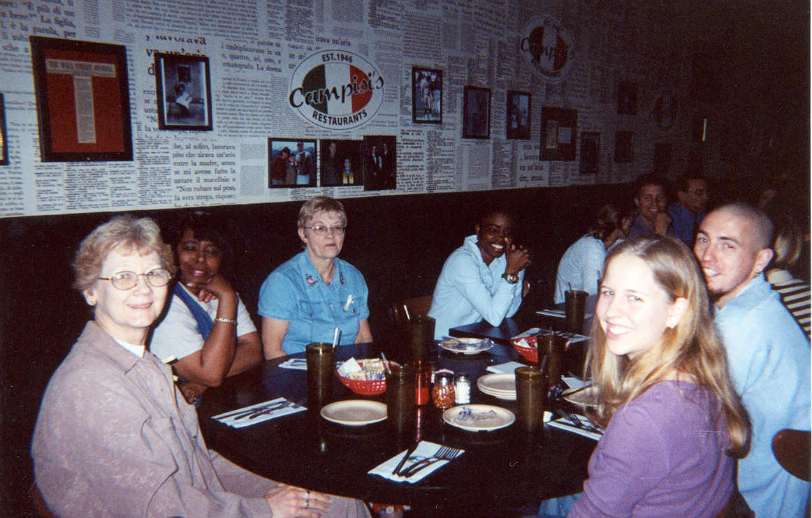picture of a group of people sitting around a table smiling at a restaurant