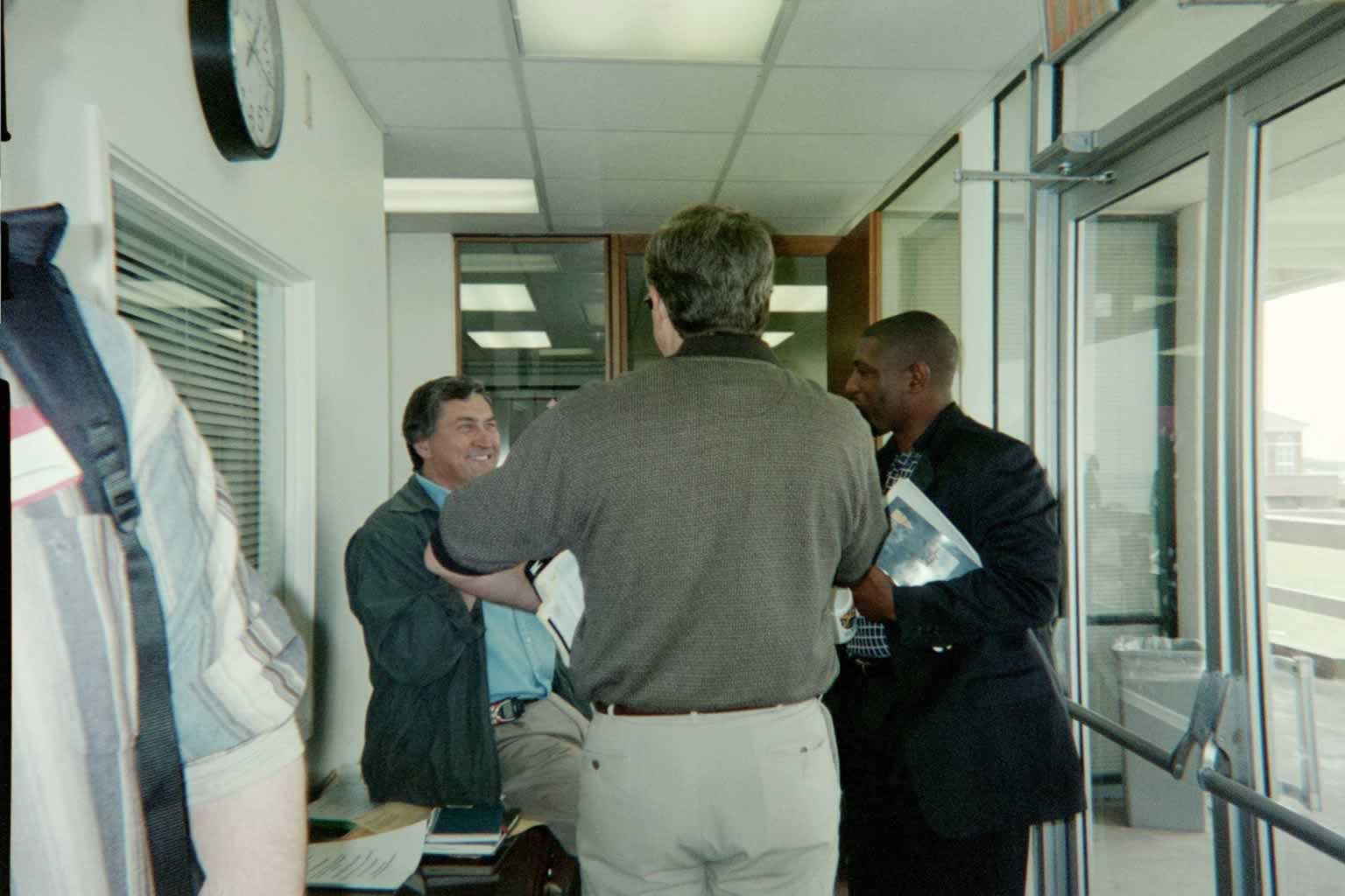 picture of Paul Marsahll standing and conversing with two other men
