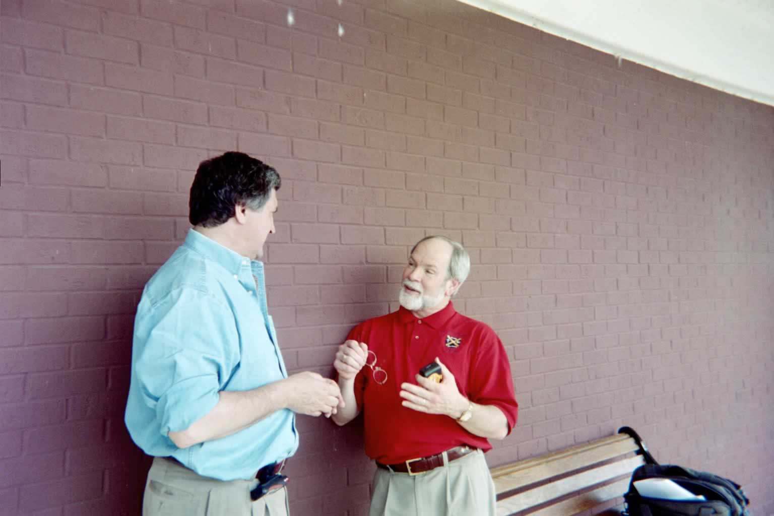 picture of Dr. Naugle and Paul Marshall talking while leaning against a wall