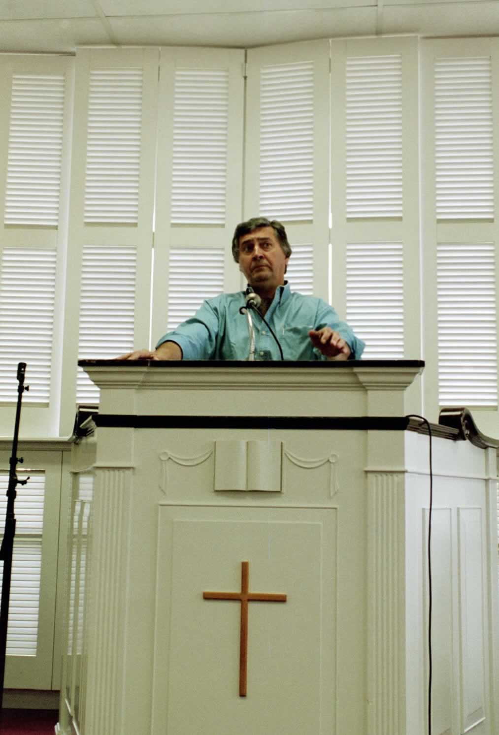 picture of Paul Marshall standing in front of a podium wearing a green shirt