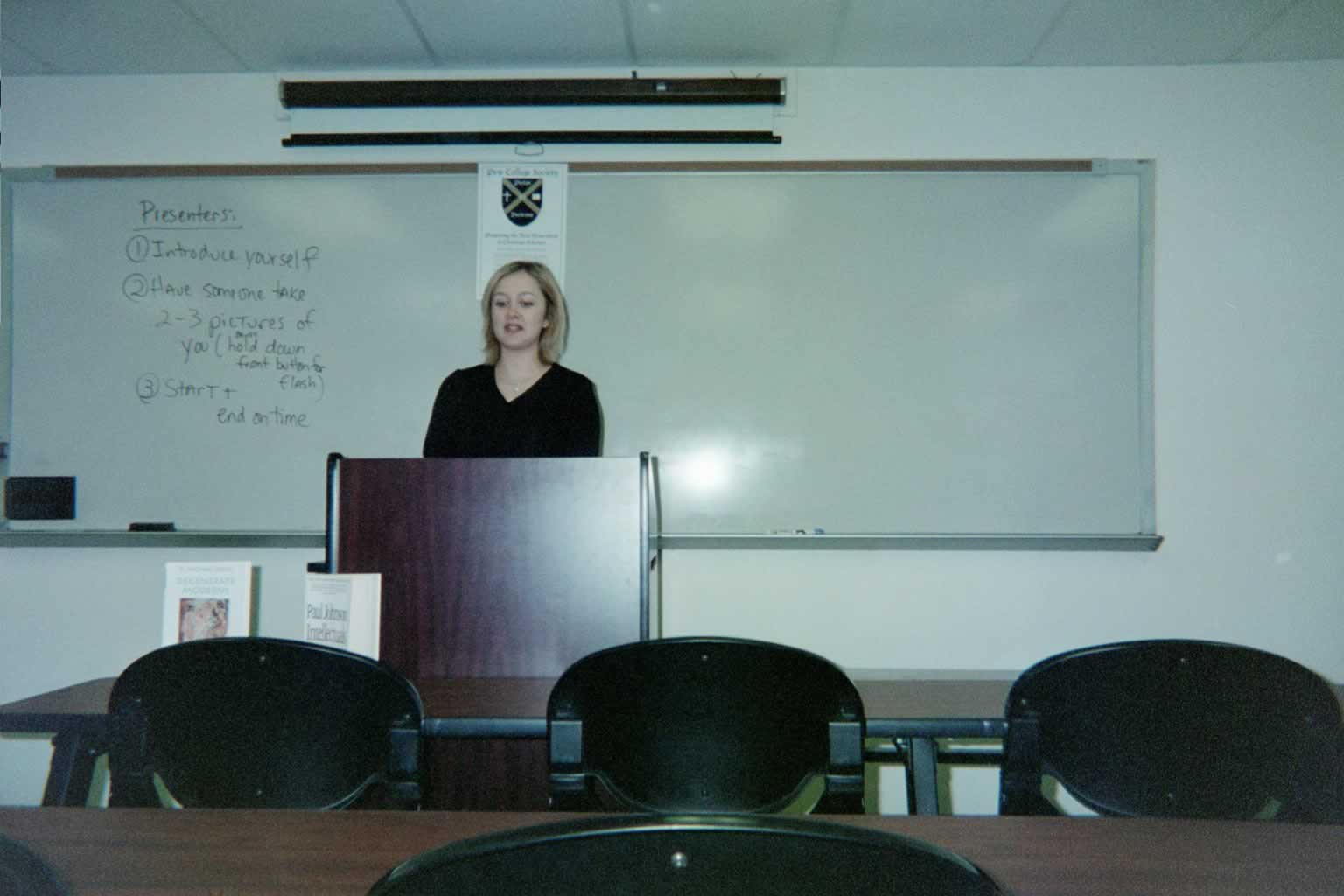 picture of a woman standing behind the podium talking while looking down