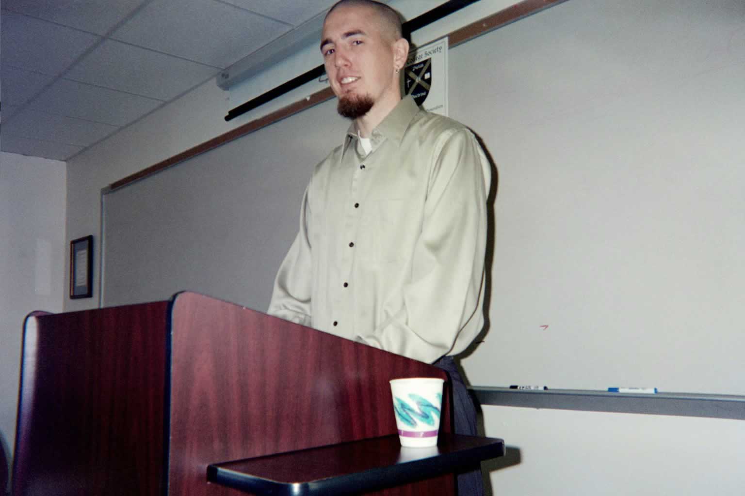 picture of a man standing behind a podium talking