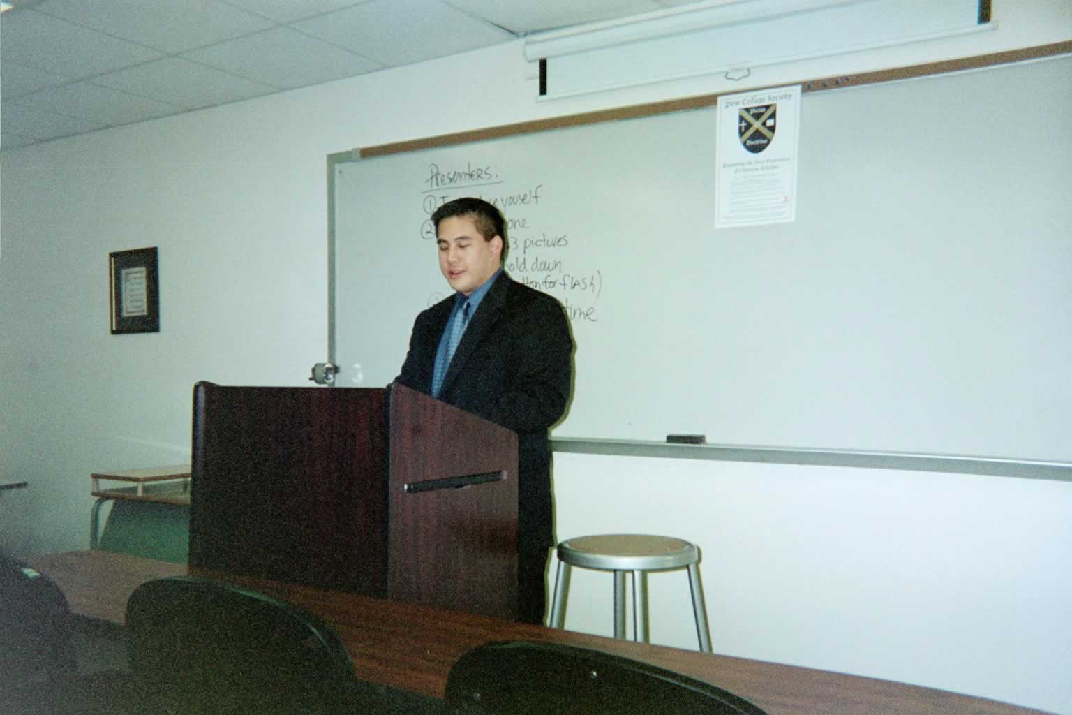 picture of a man in a suit standing behind a podium speaking