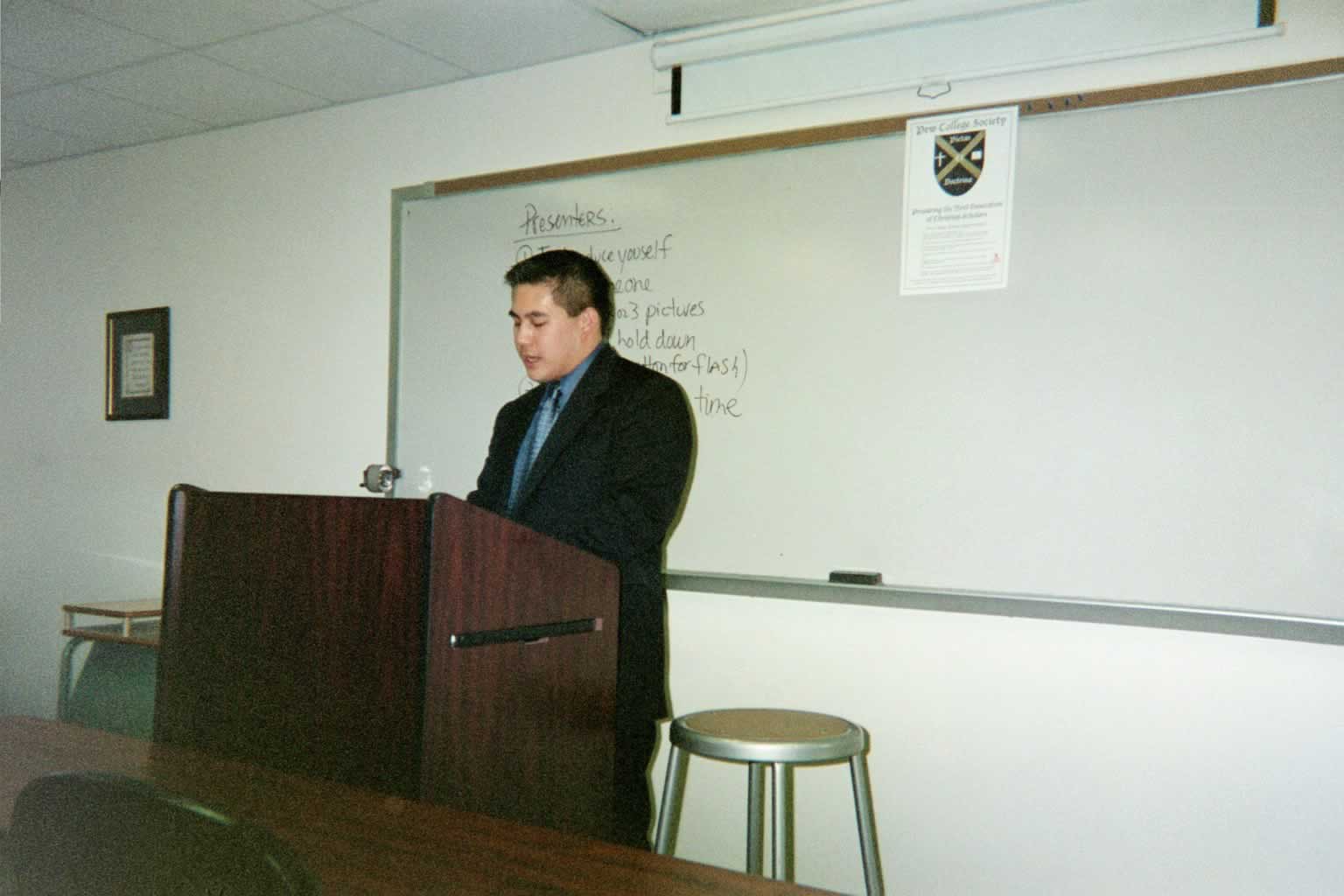 picture of a man in a suit standing behind a podium speaking