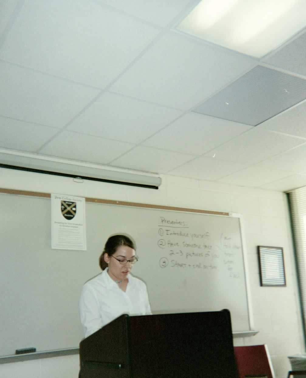 picture of a woman wearing glasses speaking behind the podium
