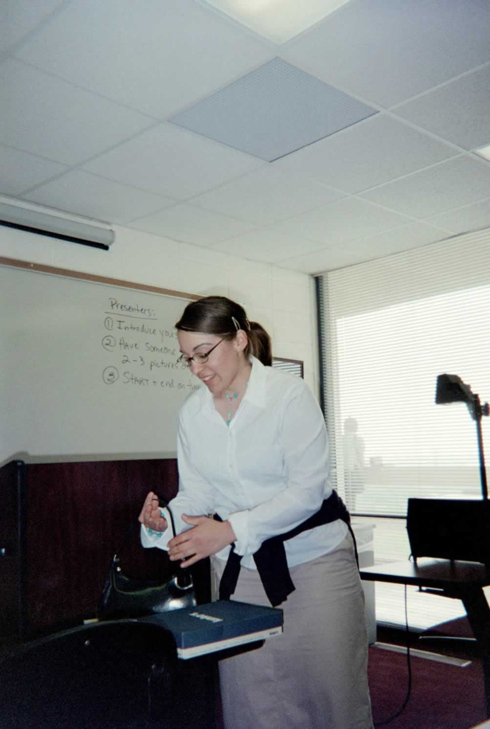 picture of a woman picking up her purse from a desk