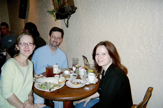 picture of two women and a man sitting at restaurant table