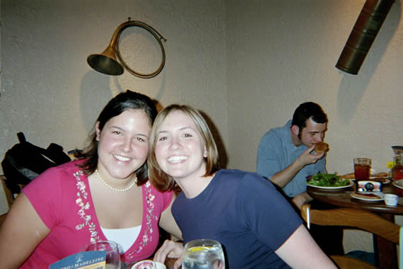 picture of two women leaning into each smiling while sitting at a resturant table