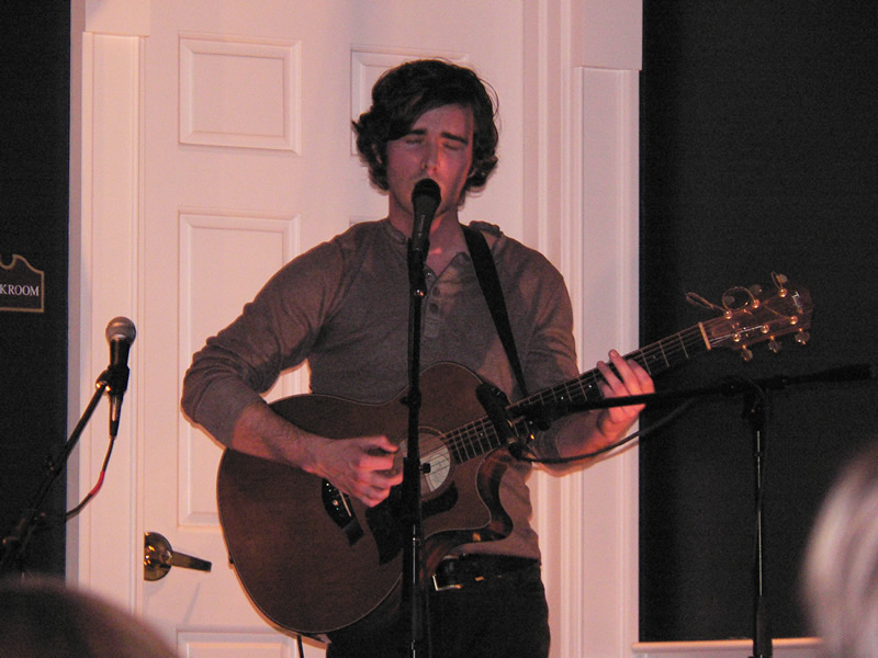 picture of Jordan Lawhead singing in front of a microphone while holding a guitar
