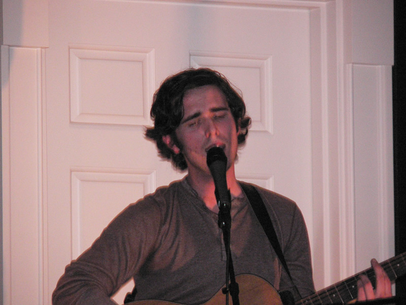 picture of Jordan Lawhead singing into a microphone while playing the guitar