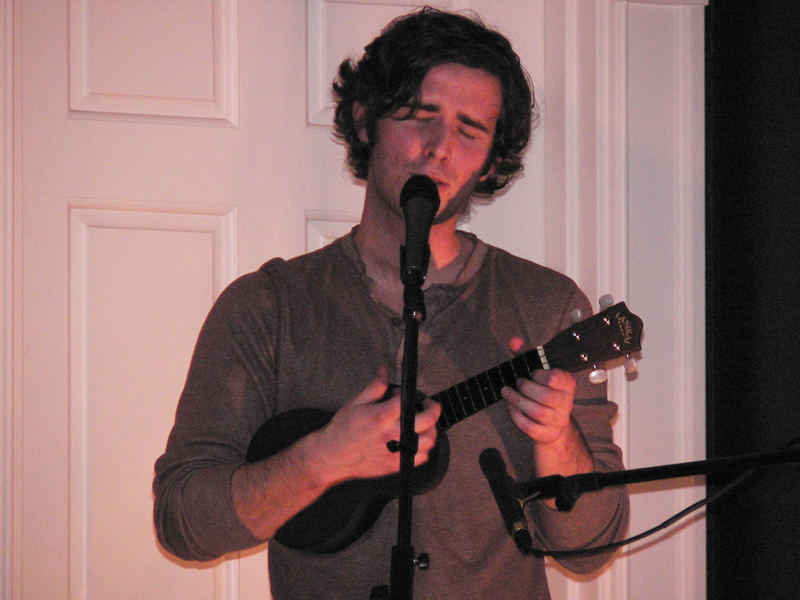 Jordan Lawhead singing into a microphone while holding a black ukulele