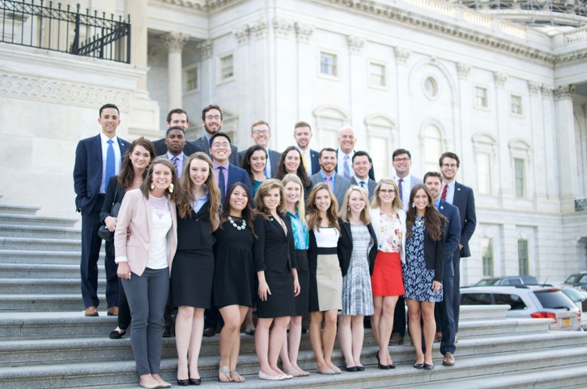 A group of students are standing in front of the nation's capital. 