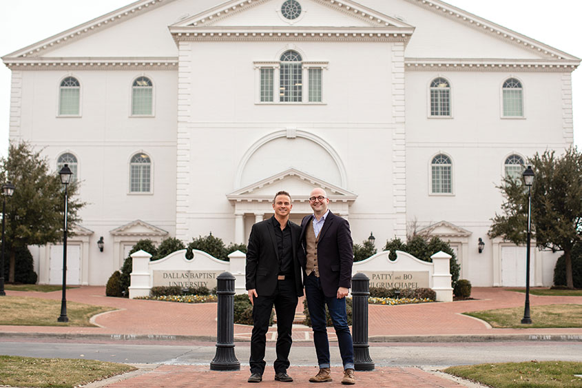 Two men are standing in front of the DBU Chapel.