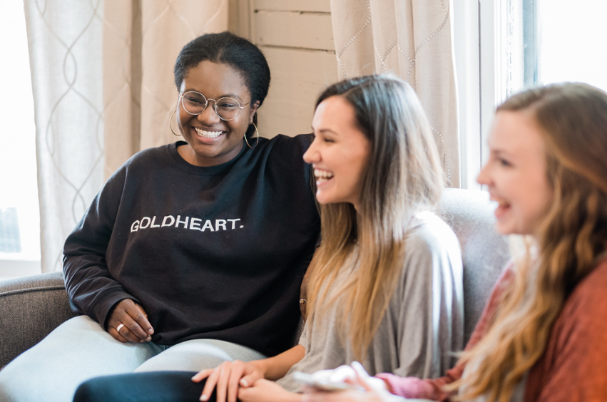 Three girls laughing on couch