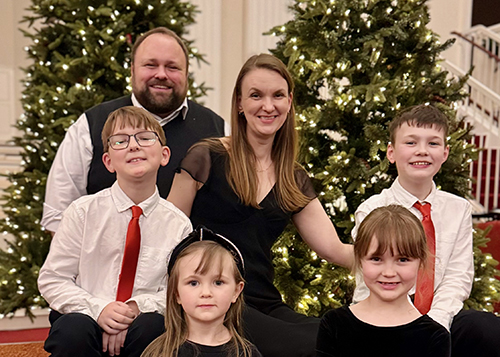 Ben Bolin with family standing in front of a Christmas tree in Dallas, Texas