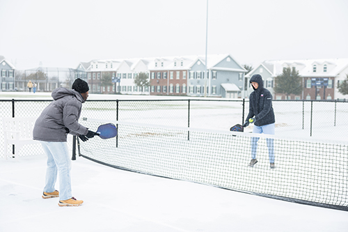 college students playing pickleball in the snow