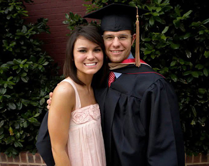 Katee and Tyler standing outside on Tyler's graduation day with his masters degree