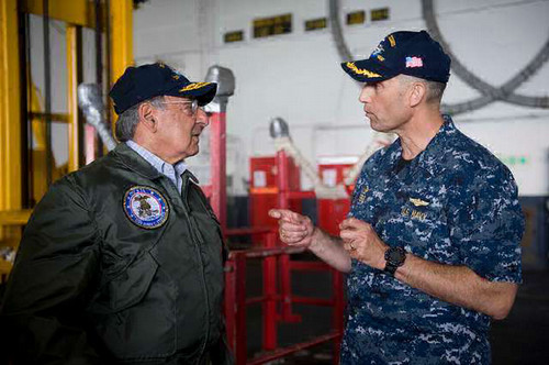 Two naval aviators engaged in a discussion inside a hangar
