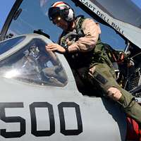 Side view of a military fighter jet cockpit. Pilot inside.