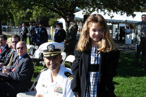 Young Bridget Reis beside her father who's in dress uniform
