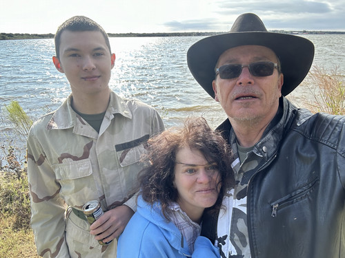 Dr. Fisher in cowboy hat & sunglasses outdoors with family